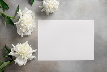 Template with white paper blank and white peonies on a gray background. Flower card. horizontal image. flat lay
