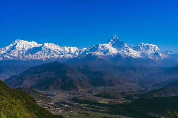 Fototapeta premium Beautiful sunrise view of mountain range with snowy peaks. Annapurna range in Himalayas. Machchapuchchre/ Fishtail, Annapurna and Himchuli Peaks, view from Sarangkot, Pokhara, Nepal.
