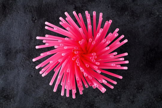 Directly Above View Of Pink Plastic Drinking Straws On Black