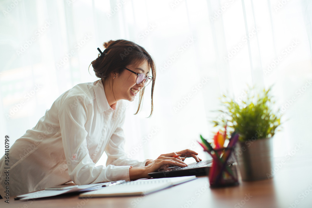 Wall mural happy young cheerful business woman at home office working on laptop