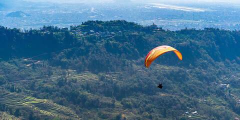 Paragliding in Nepal. Paraglider on the background Pokhara city and surrounding villages. Stock photo.