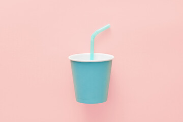 Obraz na płótnie Canvas Blue paper cup with straw on pink background