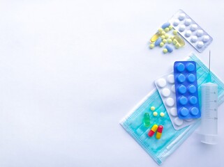 Many colorful pills and tablets in blister on the right on the background of white textured rough...