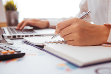 Businesswoman Writing with pen on business document