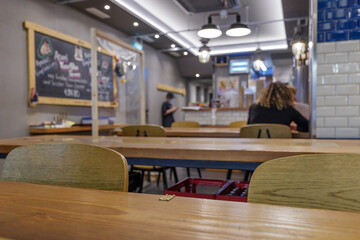 Interior view of reopening restaurant with temporary transparent plastic partition set up on wooden...