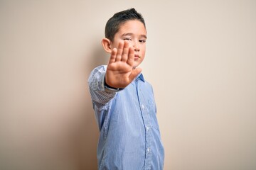 Young little boy kid wearing elegant shirt standing over isolated background doing stop sing with...