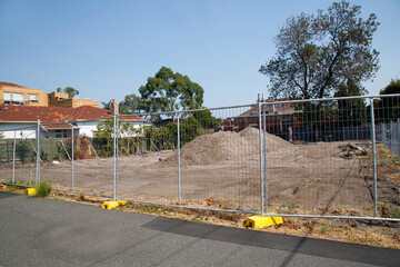 A new housing development under construction. A safety fence restricts access to the construction zone. 