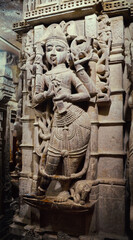 sculpture of a woman in stone in bas-relief on the wall of a temple, India