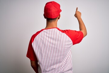 Young handsome african american sportsman wearing striped baseball t-shirt and cap Posing backwards pointing ahead with finger hand
