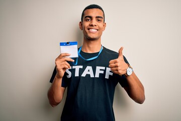 Young handsome african american worker man wearing staff uniform holding id card happy with big...