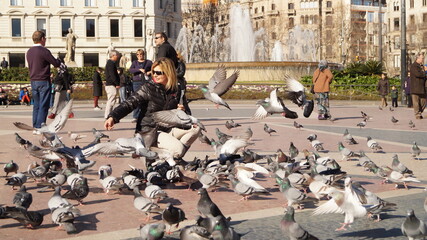 妇女在巴塞罗那公园喂鸽子