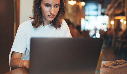 manager using laptop in cafe, hipster girl freelancer writing on keyboard, businesswoman working via portable computer and communication online, woman looking on monitor computer, learning internet