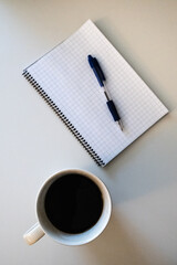cup of coffee and notebook and a pen