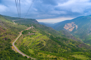 View from the cabin of the cableway to the mountains and the road, the landscape of Armenia in June