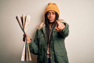 Young african american girl going on vacation holding turist city map over isolated background...