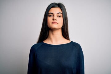 Fototapeta premium Young beautiful brunette woman wearing casual sweater standing over white background Relaxed with serious expression on face. Simple and natural looking at the camera.