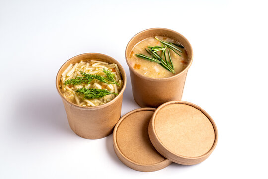 Pea and chicken soup in paper disposable cups for take-out or delivery of food on white background.
