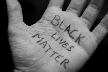 Close up of a white palm with the Black Lives Matter slogan to show support against racism and...