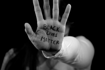Close up of a Caucasian woman's hand showing support to the Black Lives Matter movement. Black and...