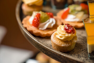 The cupcake with whipped cream. Sweet muffin on the dish. Selective focus.