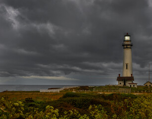Fototapeta na wymiar Pigeon Point Lighthouse on a very dark and cloudy day in the early morning