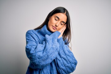 Young beautiful brunette woman wearing casual turtleneck sweater over white background sleeping tired dreaming and posing with hands together while smiling with closed eyes.