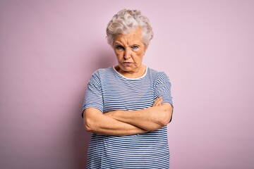 Senior beautiful grey-haired woman wearing casual t-shirt over isolated pink background skeptic and...