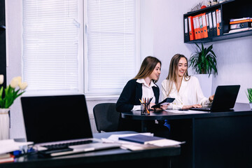 having great results! Young beautiful woman pointing at laptop w