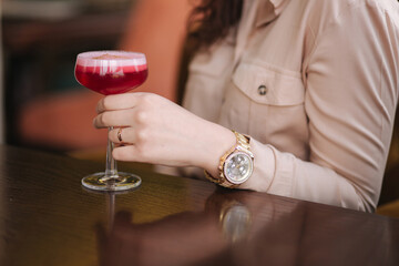 Close up of woman's hand hold cocktail in hand. Woman in restaurant