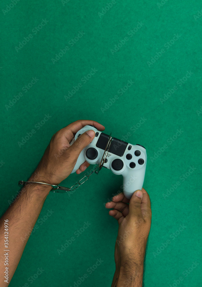 Wall mural Video game joystick and handcuffs isolated. Addiction to games concept image.