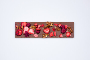 Chocolate bar with nuts, dried strawberries and raspberries.