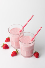 A glass of fresh strawberry smoothie on a white background. Summer drink shake, milkshake and refreshment organic concept.