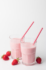 A glass of fresh strawberry smoothie on a white background. Summer drink shake, milkshake and refreshment organic concept.