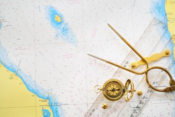 Retro styled golden compass (sundial), antique vintage W & HC 6" brass dividers calipers nautical navigation chart tool, parallel ruler, old white map close-up. Vintage still life. Sailing accessories
