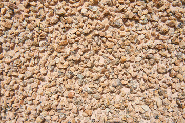 Wall surface covered with small  ginger stones. Texture. 