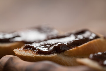 sweet breakfast baguette with chocolate hazelnut spread on wood board
