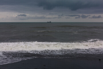 Splashing waves and cloudy sky on a pebble beach in Batumi. Autonomous Republic of Adjara, Georgia.