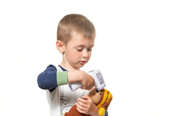 Little child measure temperature for toy bear with infrared modern digital thermometer. Flu and...
