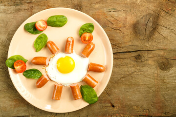 Fried eggs with sausages in the shape of a sun. Children's breakfast.
