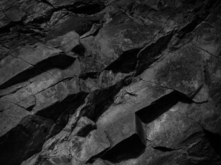 Black grunge background. Rock background. The texture of the mountains. Close-up. Black volumetric stone background.