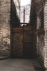 Wooden gate between brick walls