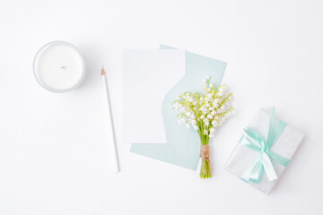 Mockup white wedding invitation and envelope with white flowers on a white background