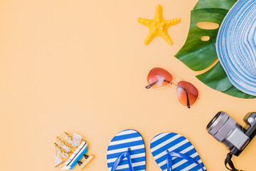 Flat lay composition with a summer hat and flip flops on a yellow background
