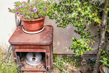 Rusty wood burner used as outdoor decoration in an English country garden