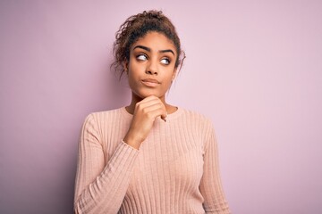 Fototapeta na wymiar Young beautiful african american girl wearing casual sweater standing over pink background with hand on chin thinking about question, pensive expression. Smiling with thoughtful face. Doubt concept.