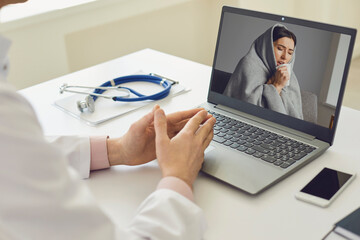 Online doctor and patient. A patient with flu symptoms has a video chat conference call with...