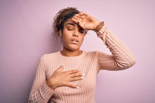 Young beautiful african american girl wearing casual sweater standing over pink background Touching forehead for illness and fever, flu and cold, virus sick