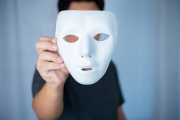 hand holding unidentified white mask for fake or hide himself from other