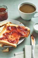 coffee and toast with jam, a healthy wholesome snack, a cup of black coffee and 2 toast with jam, breakfast started