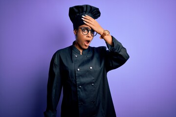 Young african american chef girl wearing cooker uniform and hat over purple background surprised with hand on head for mistake, remember error. Forgot, bad memory concept.